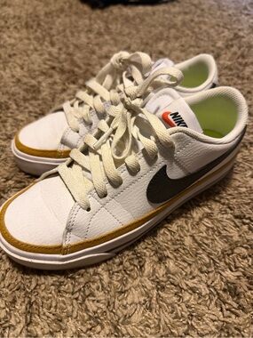 Nike Kids White Leather Sneakers with Black Swoosh and Gold Accent